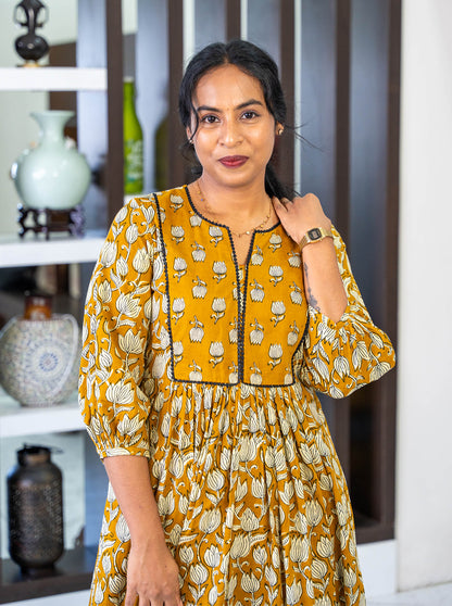 Close-up of tanned yellow floral motif cotton fabric texture - Ariyaa