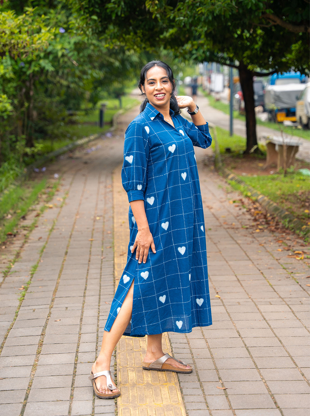 Model seated on a bench in indigo heart print cotton shirt dress with 3/4 sleeves - Ariyaa