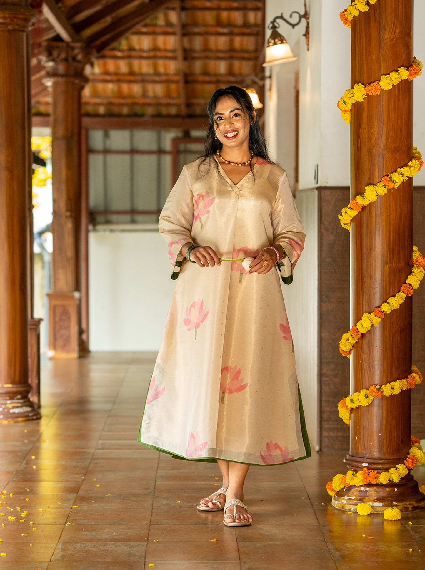 Flat lay of peach gold lotus print silk kurti with green trim - Ariyaa