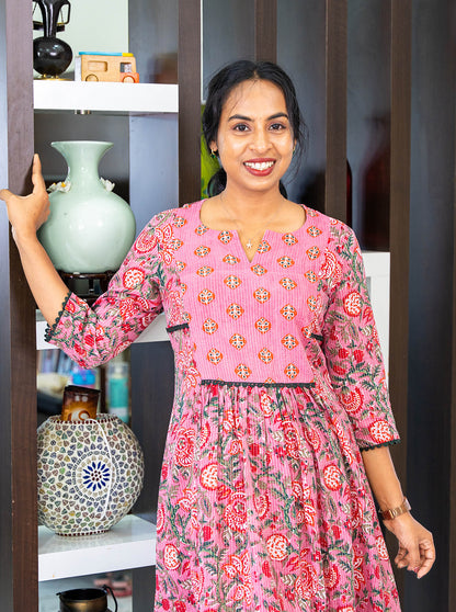 Detail of buti print yoke, round neck with V cut and lace trim on pink kurti - Ariyaa