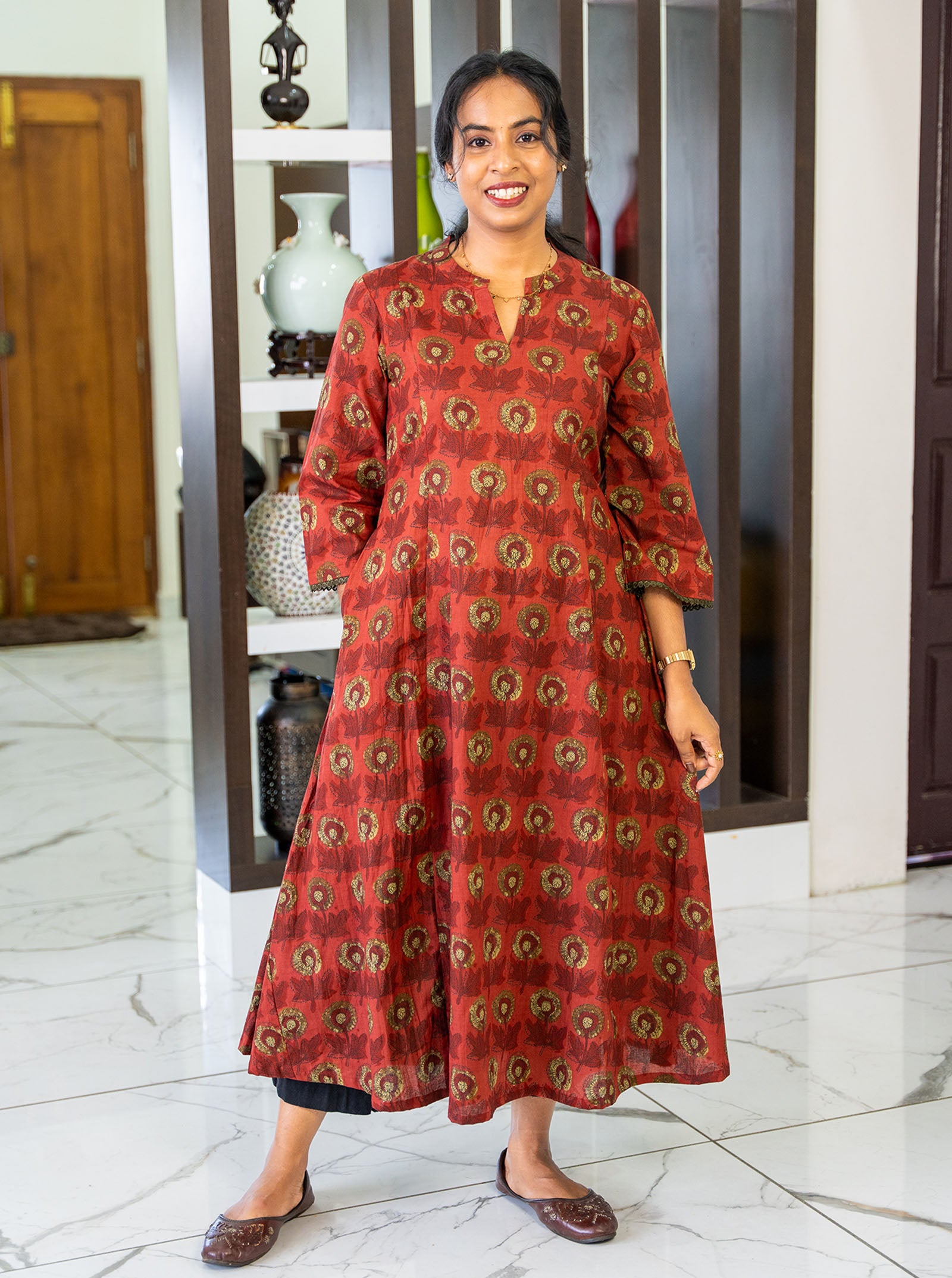 Flat lay of dark terracotta floral A-line cotton kurti with pockets - Ariyaa