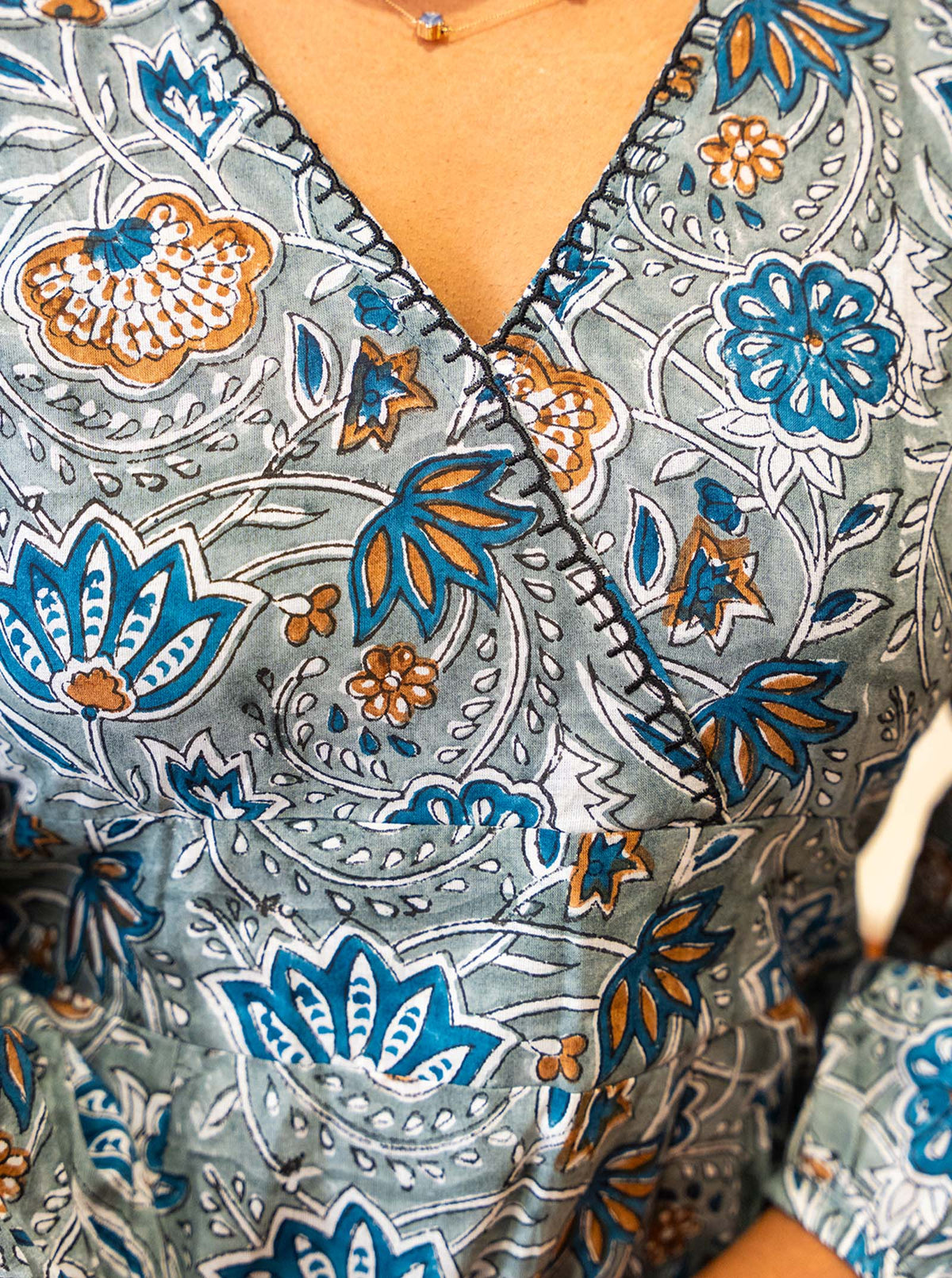 Detail of teal and ochre floral hand block print on grey cotton - Ariyaa