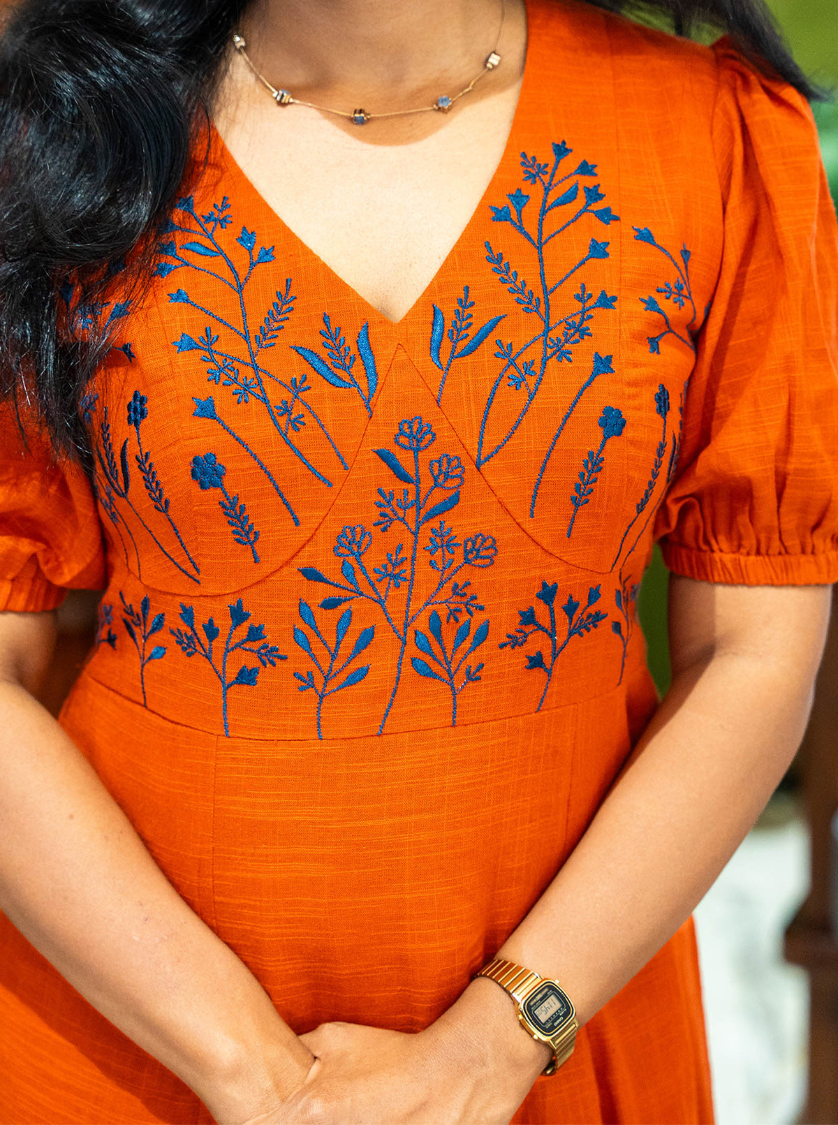 Detail of blue botanical embroidery on orange slub cotton yoke - Ariyaa