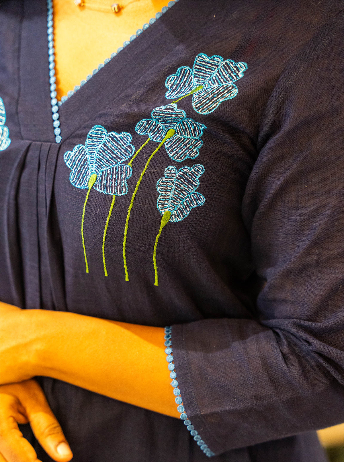 Detail of embroidered poppies and lace trimmed 3/4th sleeve on navy cotton - Ariyaa