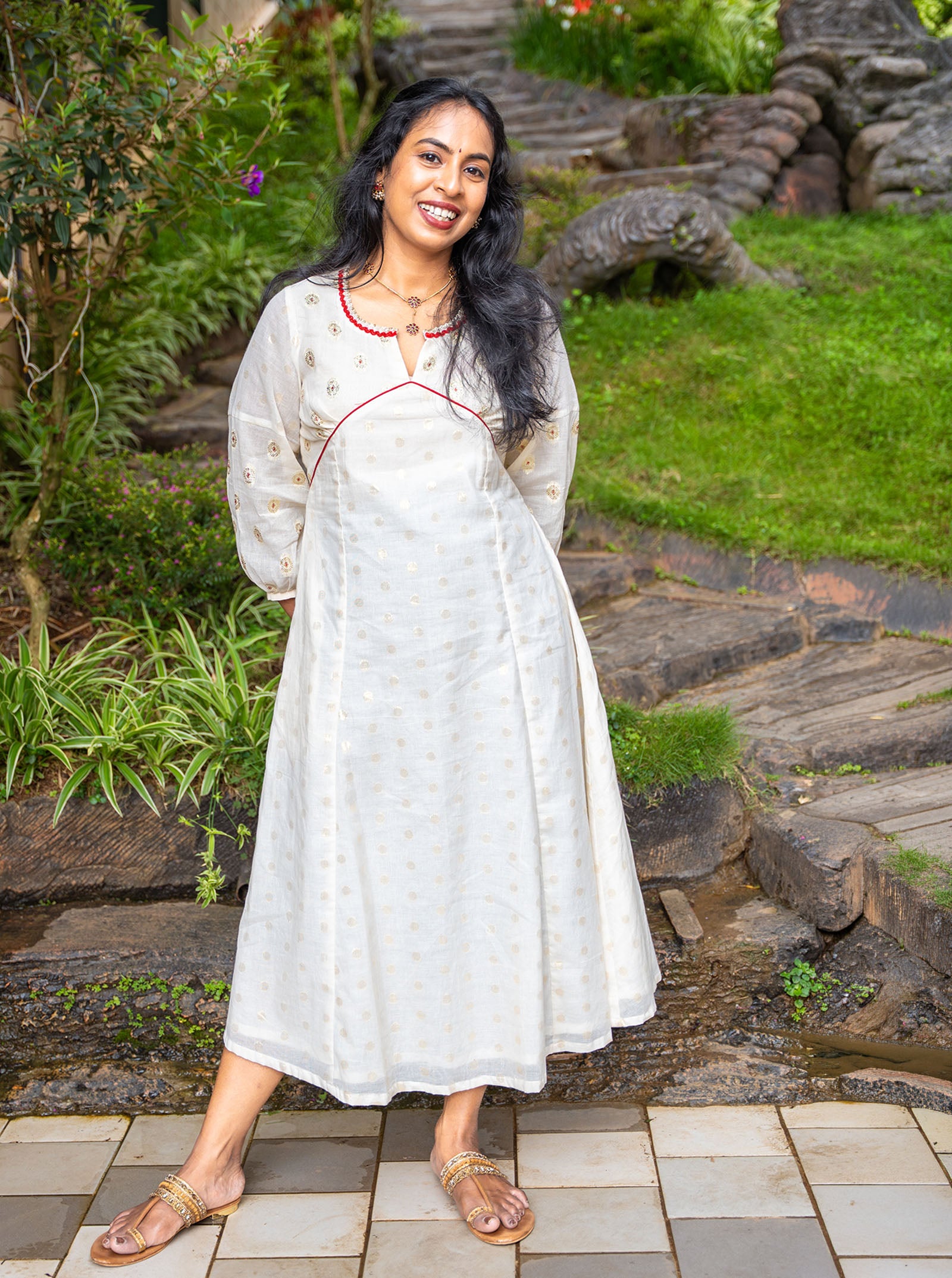 Cream golden butti kurti styled with juttis and jhumkas for Onam - Ariyaa